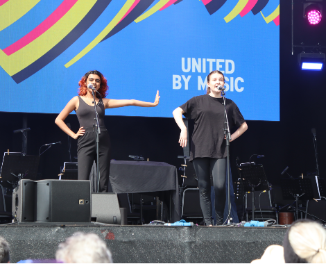 Two female students from Liverpool Hope University sing on stage at the Eurovision Village.